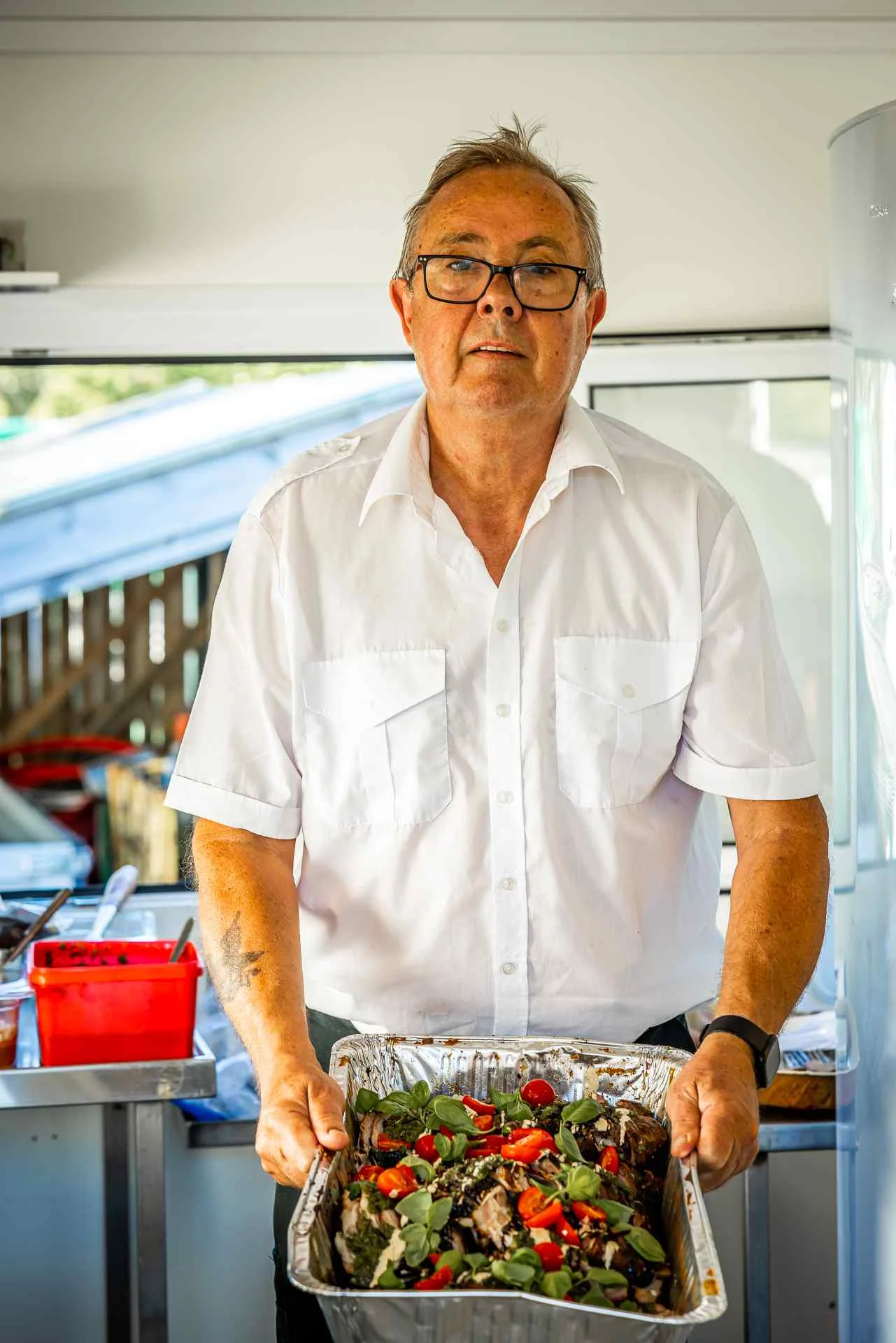 Terje viser frem mat i aluminiums bakk